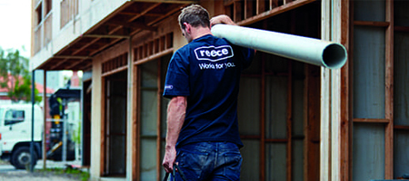 Plumber carrying pipe