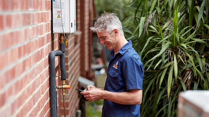 Man wearing Reece shirt holding mobile phone