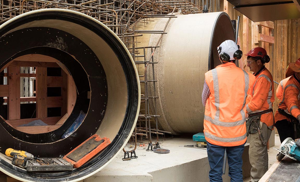 Workers standing with HOBAS pipe
